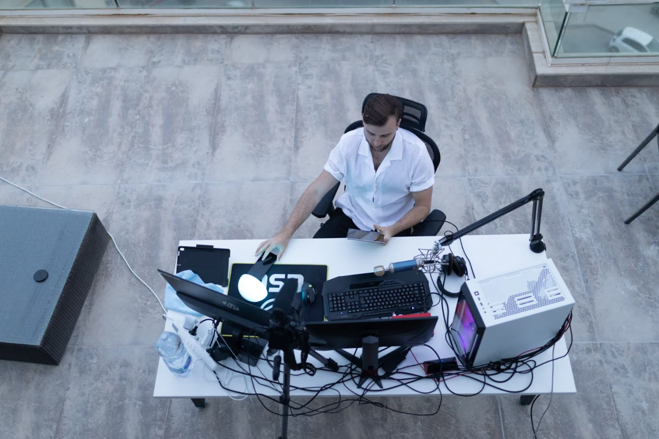 Vue du dessus : Théo Bayoux à son bureau de montage en terrasse