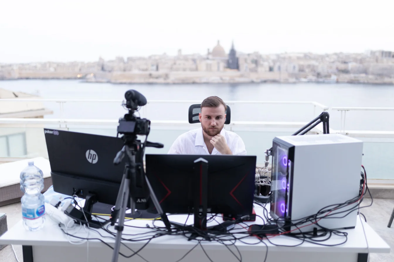 Théo Bayoux concentré devant ses écrans, la mer en arrière-plan