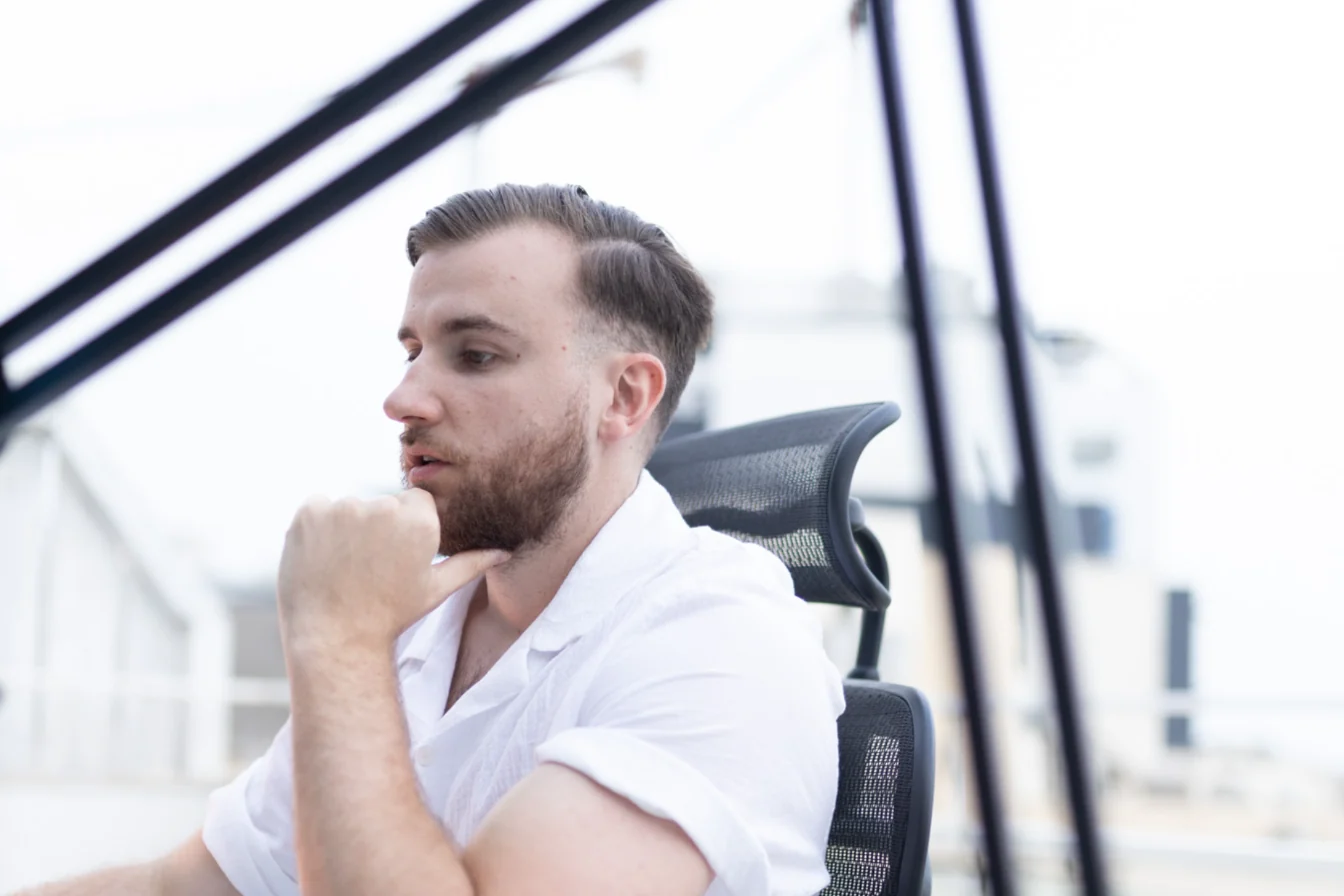 Théo Bayoux réfléchit à son bureau de montage, la main sous le menton