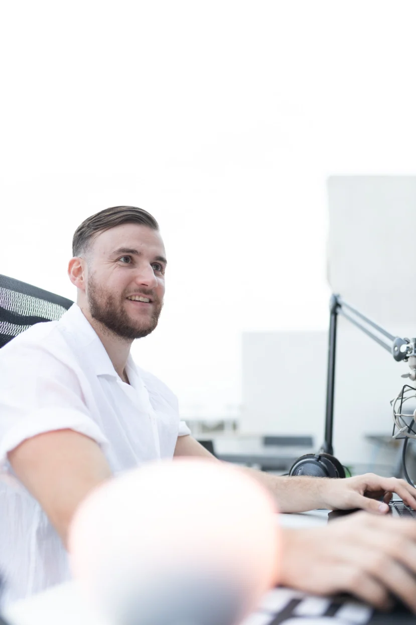 Théo Bayoux souriant à son bureau de montage, micro à côté
