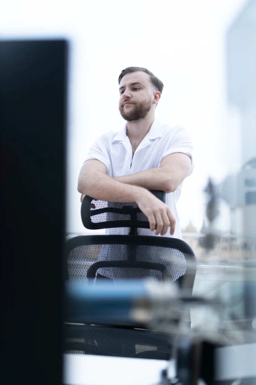 Théo Bayoux derrière sa chaise de bureau, regard au loin