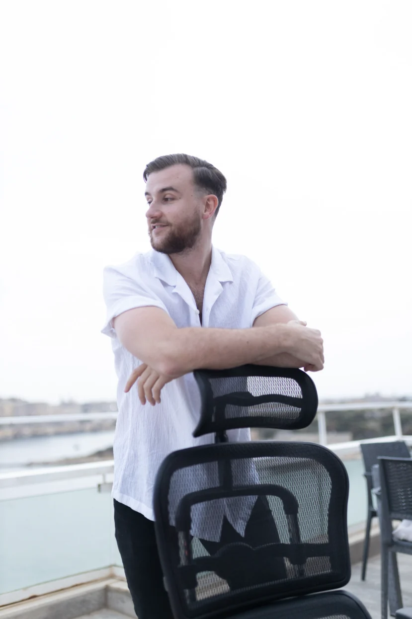 Théo Bayoux appuyé sur sa chaise de bureau, sur la terrasse