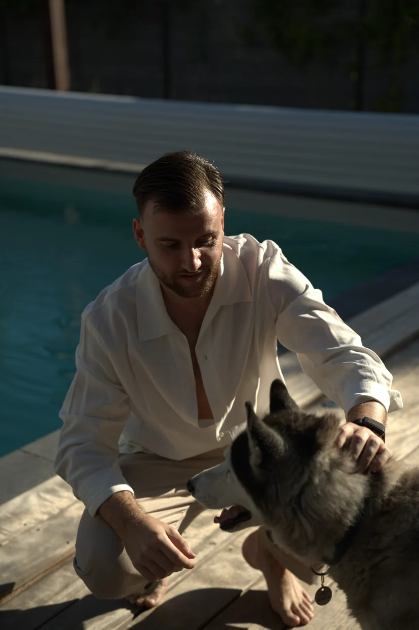 Théo Bayoux caresse son husky au bord de la piscine
