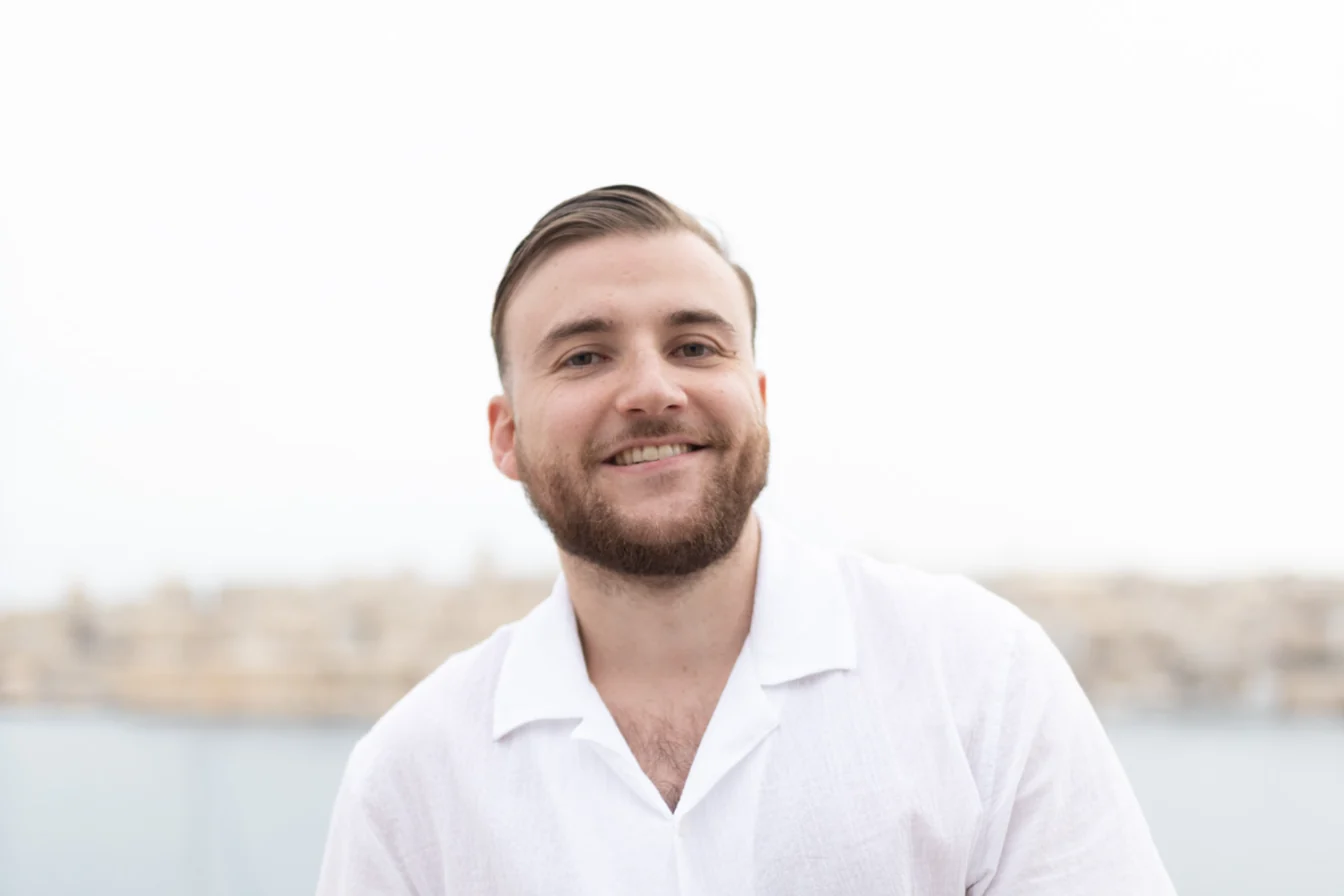 Portrait de Théo Bayoux souriant, la mer en arrière-plan